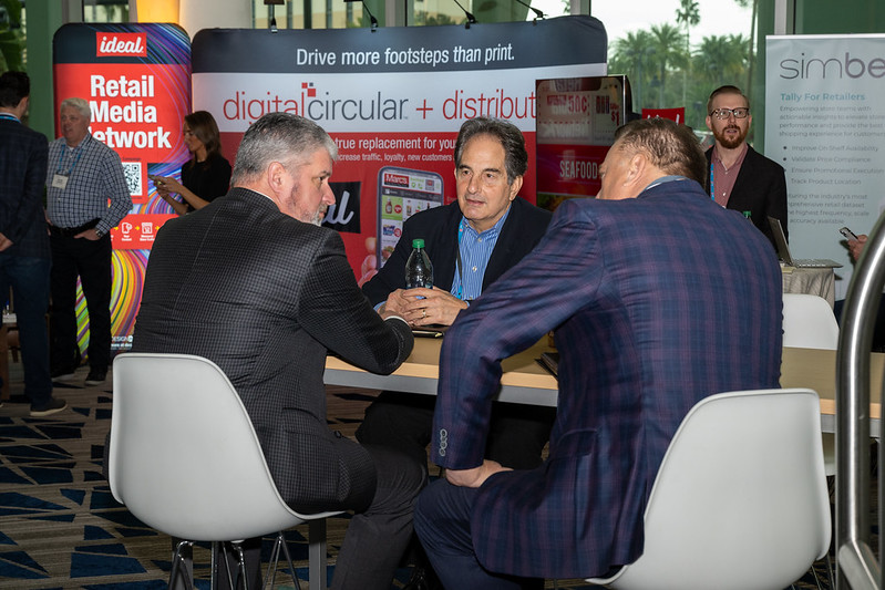 Guests discussing business at the FMItech Lounge in 2023