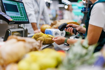 A store associate scanning items at checkout