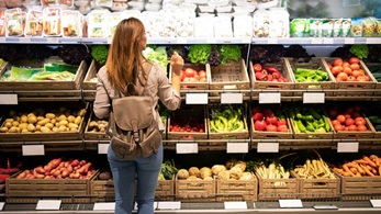 Girl looking at produce in grocery store
