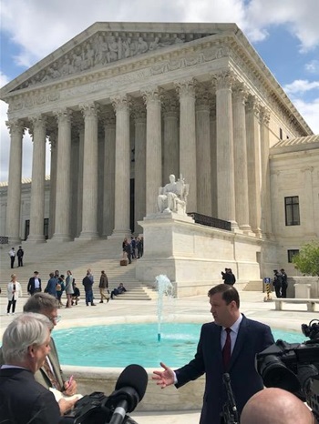 mg-caption: FMI's Attorney, Evan Young, Baker Botts, received questions from the media outside the U.S. Supreme Court following oral arguments.