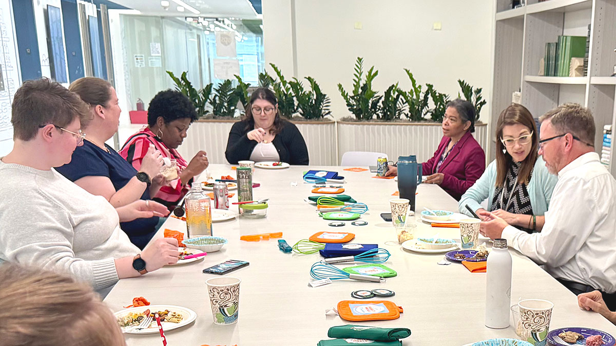 mg-caption:FMI Staff enjoying a 'Family Meal' at our second recipe exchange and potluck.