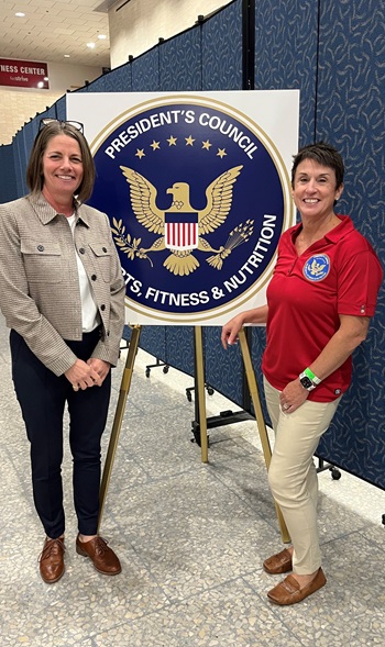 Two women in front of presidential seal