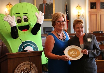 Leslie Sarasin gives Price Chopper’s Ellie Wilson the Gold Plate Award for their Family Mealtimes Matter program