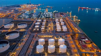 A large oil and natural gas storage facility next to the ocean.