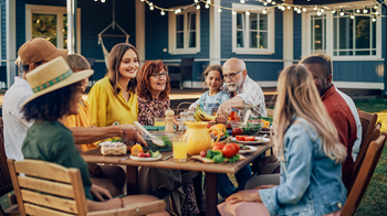 Family eating outside with food on table