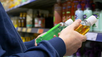 Customer looking at shampoo in grocery store